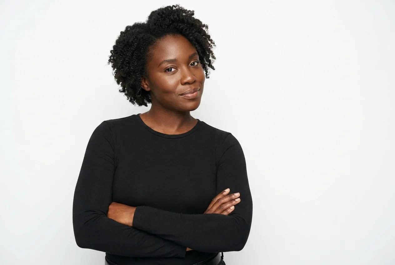 A woman with her arms folded, a quiet confident half-smile