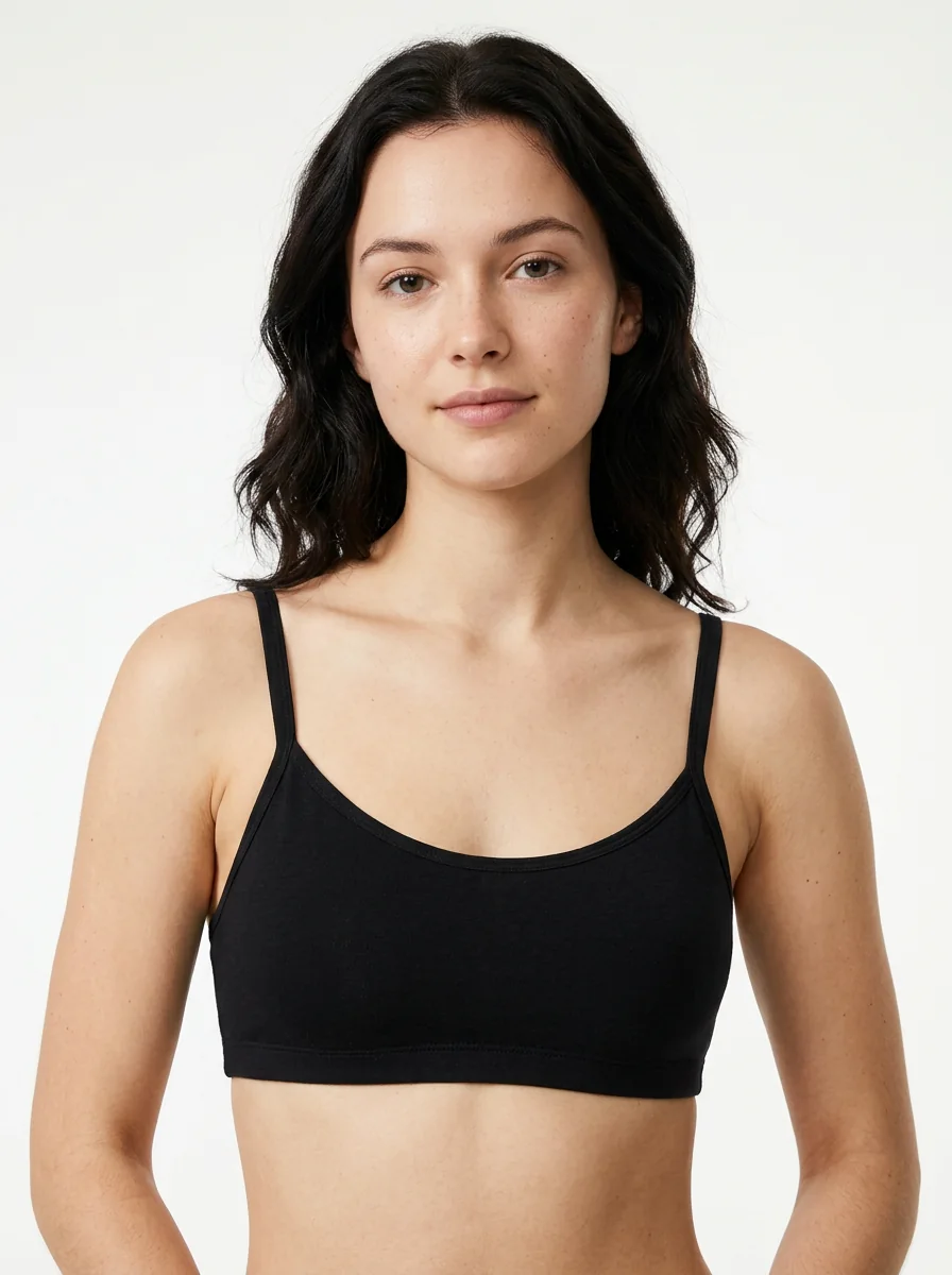 A model in a plain black bra, collarbone and shoulders in frame