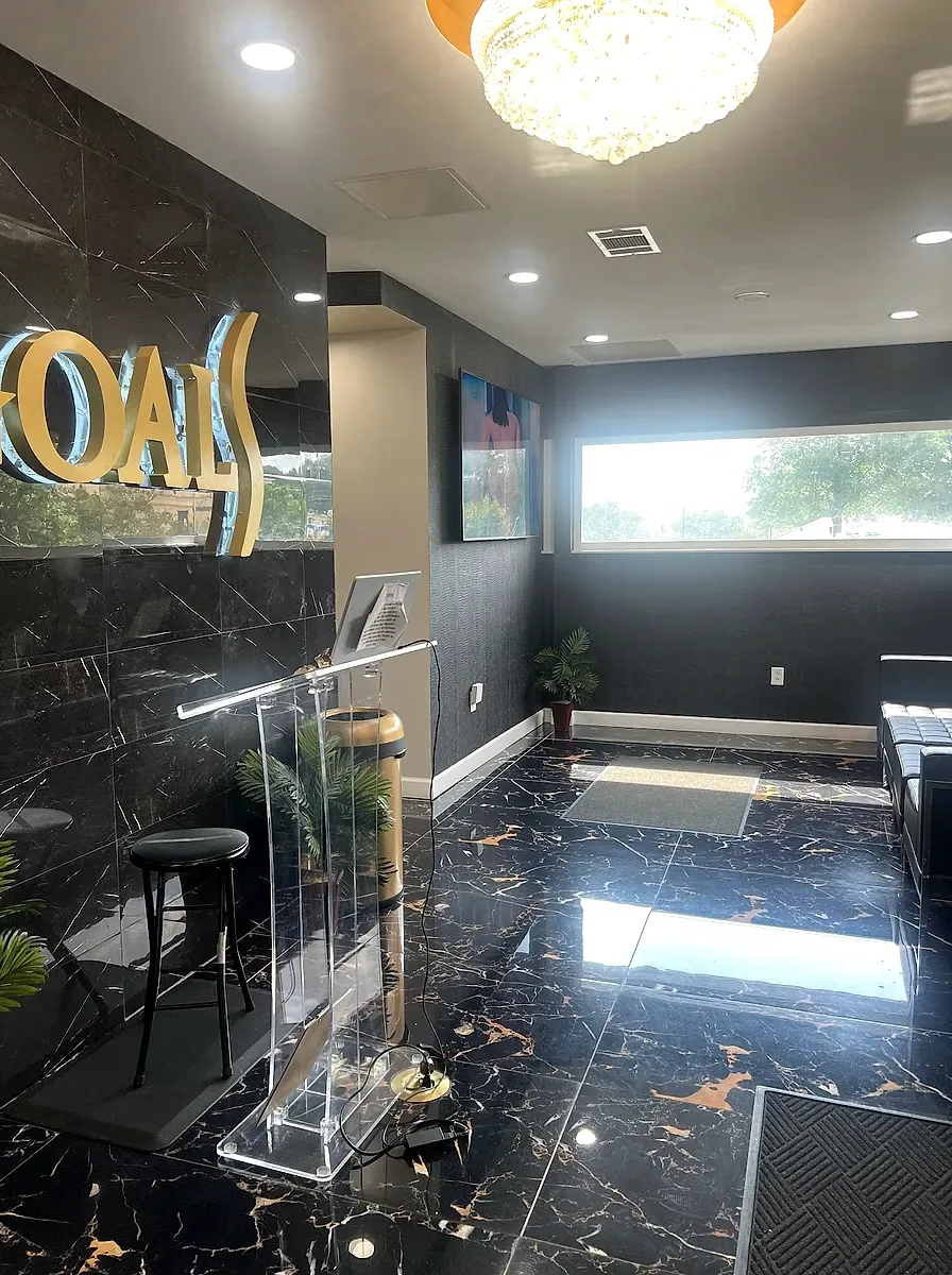 Reception at the Goals clinic in Atlanta, with the gold Goals sign on a dark marble wall